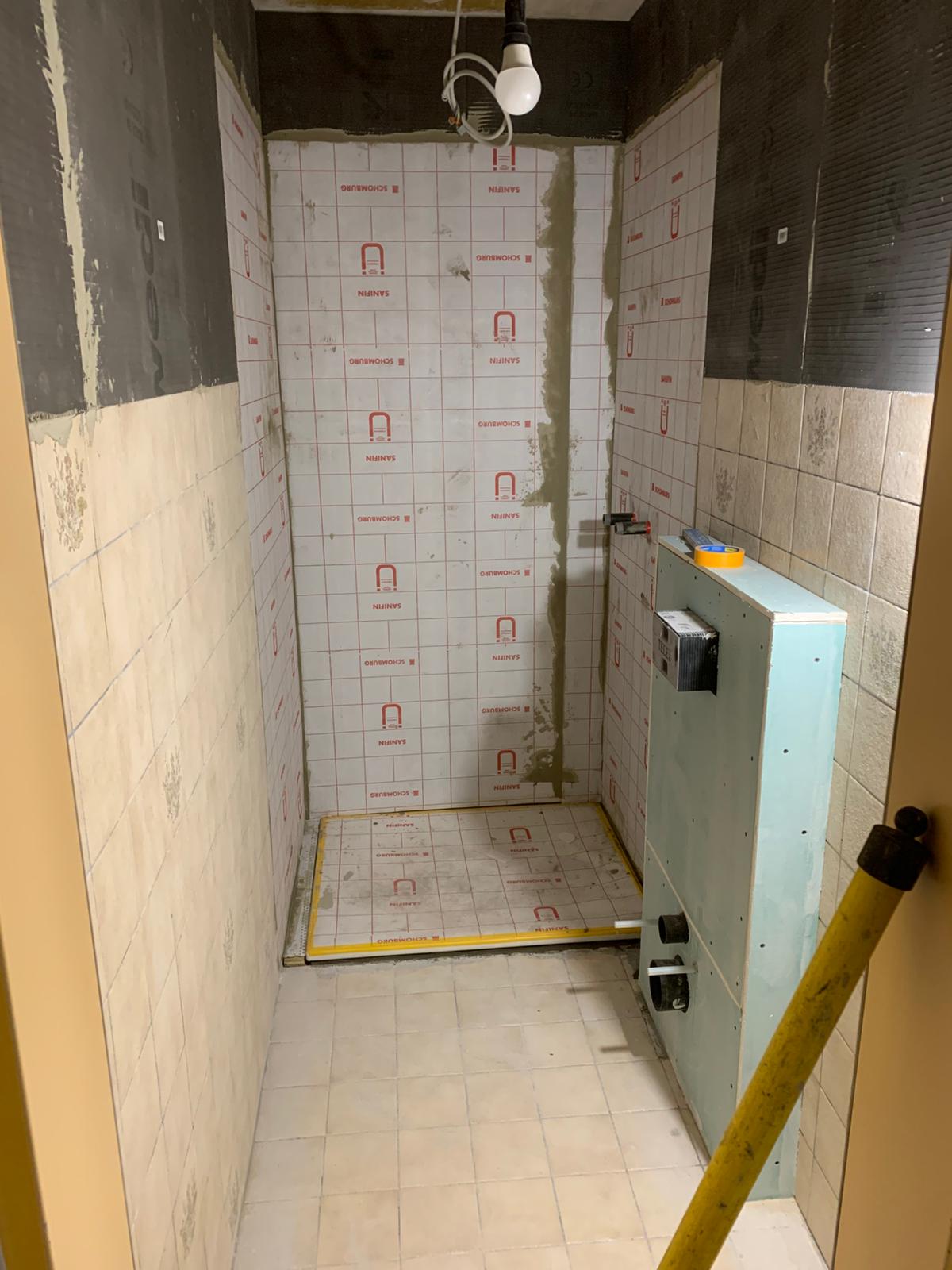 Duschbereich im Umbau mit Schomburg-Abdichtungsbahn an Wänden und Boden sowie einem Vorwandelement für die Sanitärinstallation