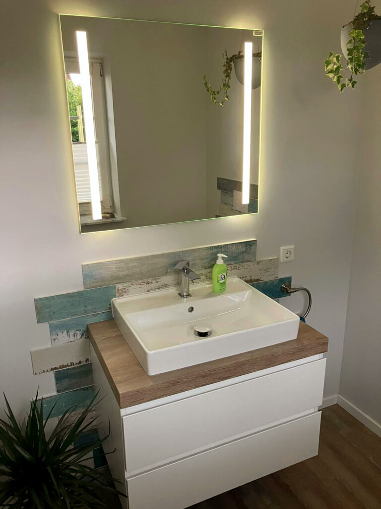 Eine Badsanierung, mit einem wunderschönen Spiegel und Waschbecken.